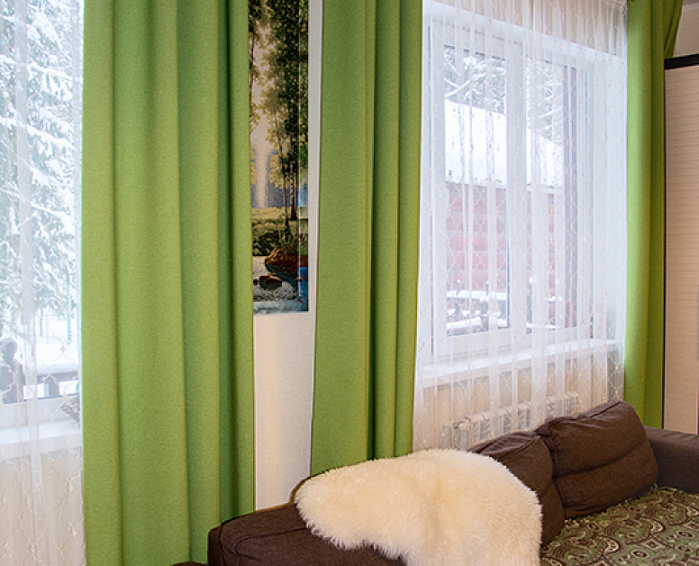 Зеленые шторы на люверсах в гостиной